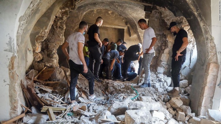 イスラエル軍の作戦行動によって破損した建物を調べるパレスチナの人々/Raneen Sawafta/Reuters