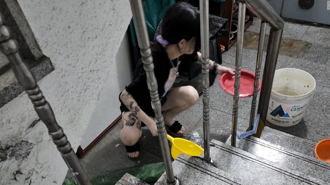 浸水したアパートの地下で水をくむ女性＝１０日、韓国・ソウル/Twitter
