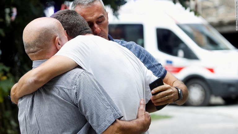 銃乱射の現場で互いに慰め合う犠牲者の遺族ら/STEVO VASILJEVIC/X01084/REUTERS