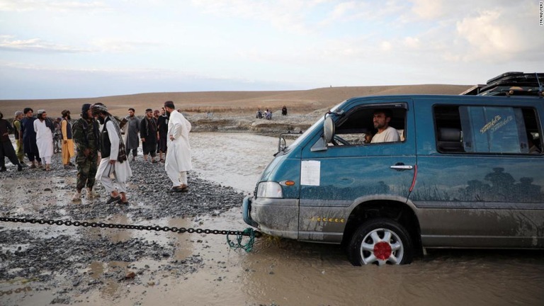 冠水した道路にはまったミニバン＝２１日、アフガニスタン/Str/Reuters