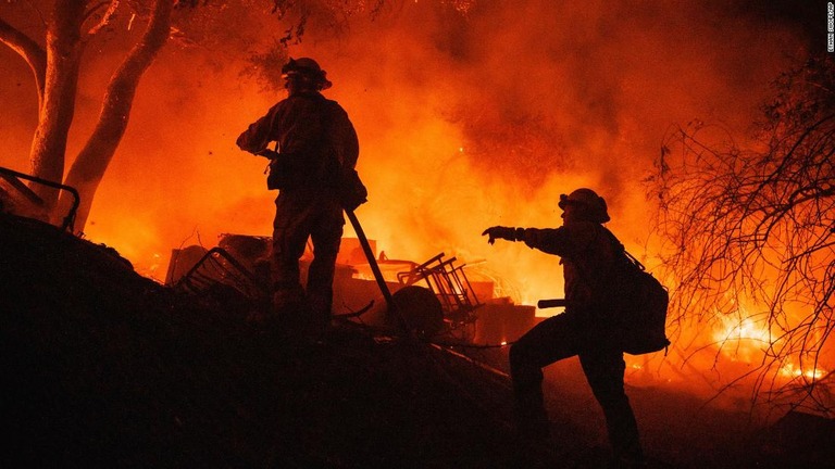 勢いよく燃え広がる米カリフォルニア州南部の山火事に対処する消防隊員ら/Ethan Swope/AP