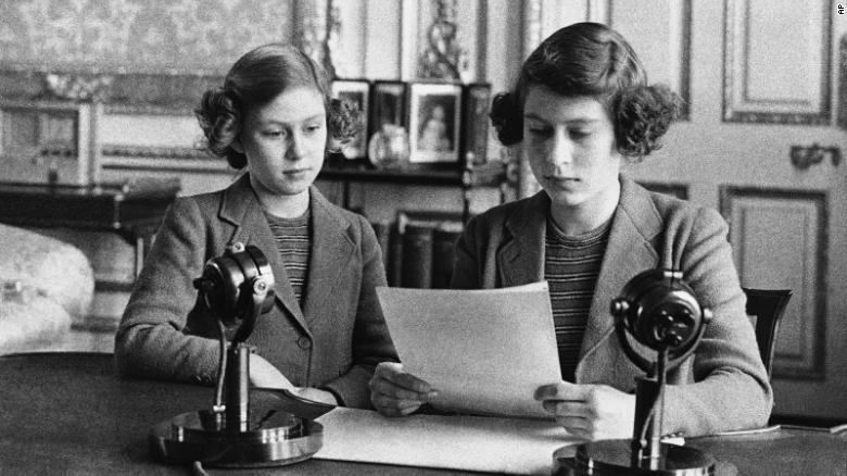初のラジオ放送に妹とともに臨む１４歳当時のエリザベス女王（右）＝１９４０年１０月１３日/AP