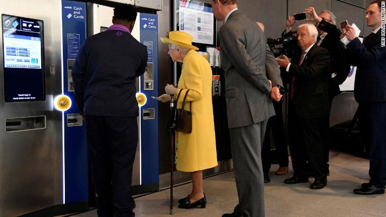 ロンドン地下鉄の新路線「エリザベス線」の開通式でパディントン駅の券売機から切符を購入するエリザベス女王＝２０２２年５月/Toby Melville/Reuters