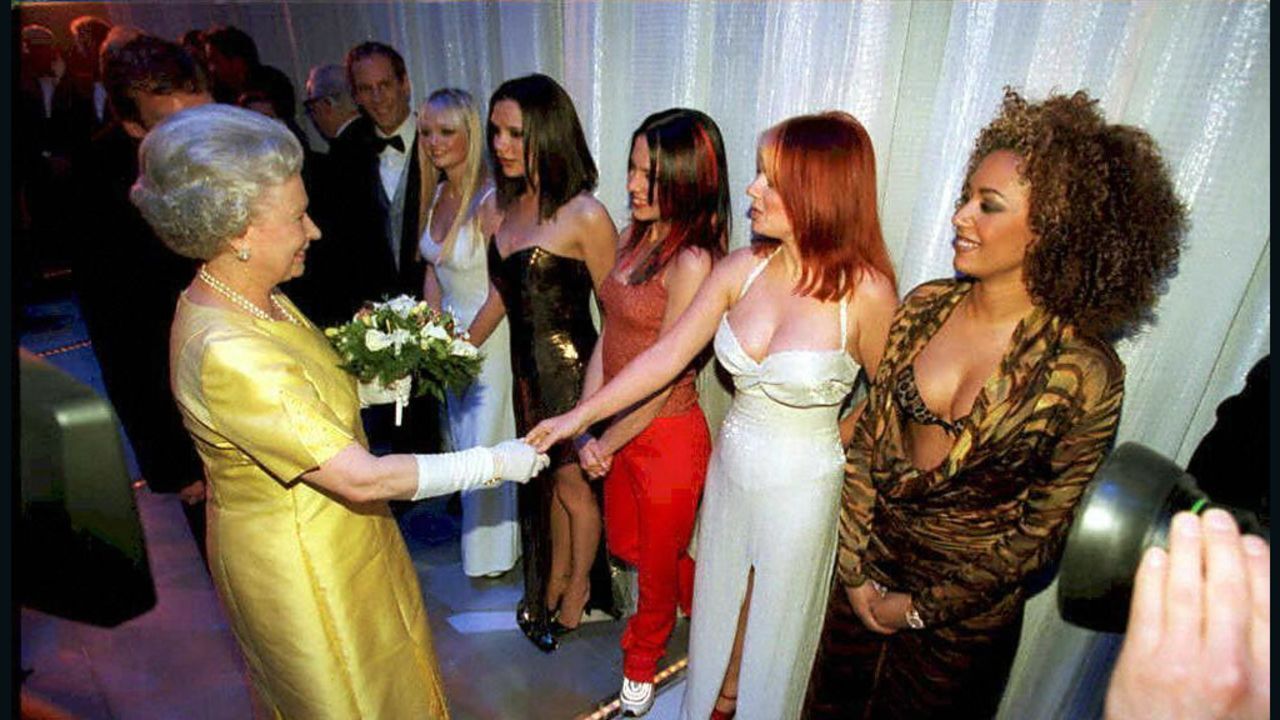 スパイス・ガールズのメンバーと握手を交わすエリザベス女王＝２００１年/AFP/Getty Images