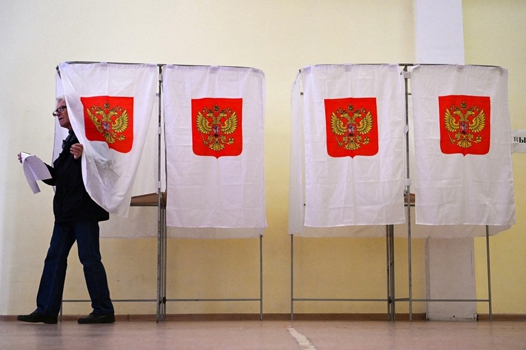 ロシアの地方選でモスクワの投票所のブースを後にしようとする男性/Natalia Kolesnikova/AFP/Getty Images