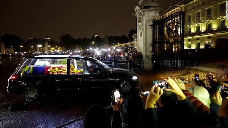 エリザベス女王の棺を運ぶ車を見守る人々＝１３日、ロンドン/Andrew Boyers/Reuters