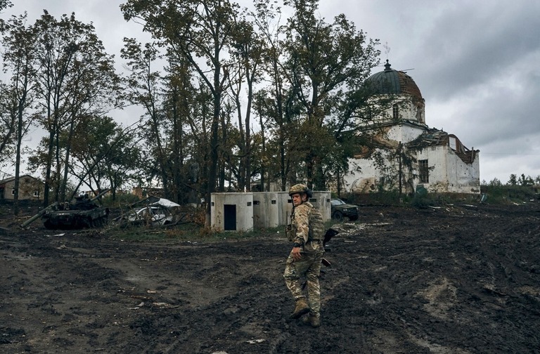 ウクライナ・ハルキウ州イジュームの地を歩くウクライナ兵＝１３日/Kostiantyn Liberov/AP