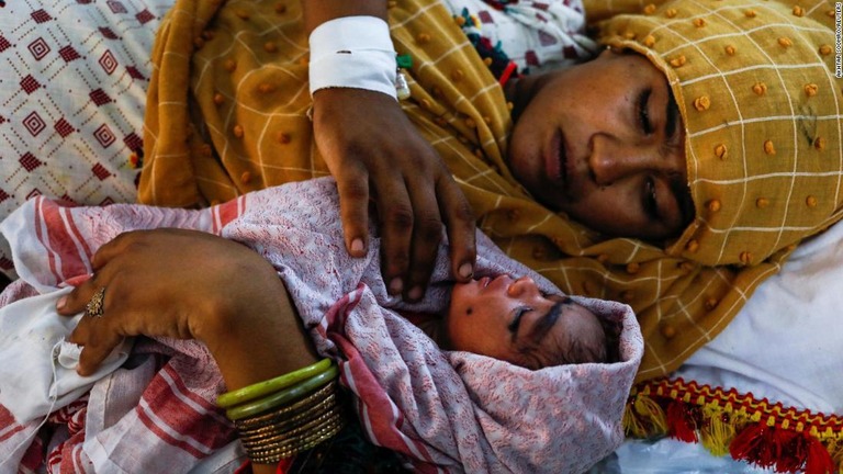赤ちゃんを抱く母親＝パキスタン・セーワン/Akhtar Soomro/Reuters