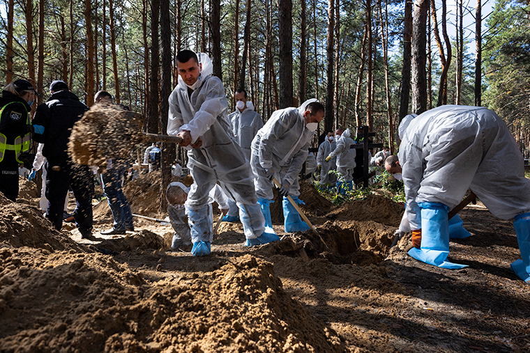 無名の墓から遺体を掘り起こす作業員ら＝１９日、ウクライナ東部イジューム/Paula Bronstein/Getty Images