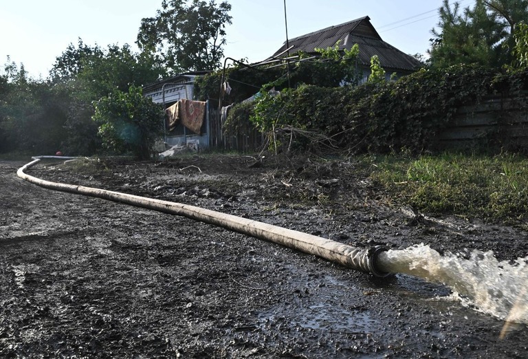 付近のダムが攻撃を受けた後、クリビーリフの住宅外のホースから水が噴き出る様子/Genya Savilov/AFP/Getty Images