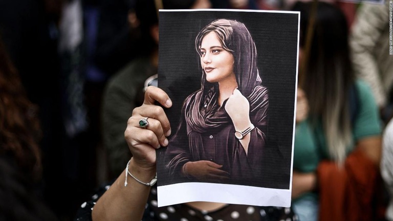 死亡したマフサ・アミニさんの肖像を掲げるデモ参加者/Kenzo Tribouillard/AFP/Getty Images