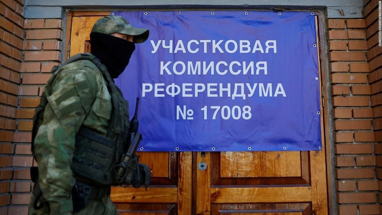 ロシア編入の是非を問う住民投票の投票所前を歩く「ドネツク人民共和国」の兵士/Alexander Ermochenko/Reuters