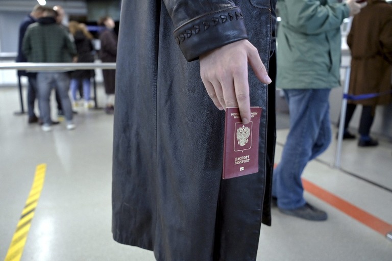 ロシアとフィンランドの国境にあるバーリマーの検問所でパスポートを持つロシア市民＝２５日/Jussi Nukari/Lehtikuva/Reuters