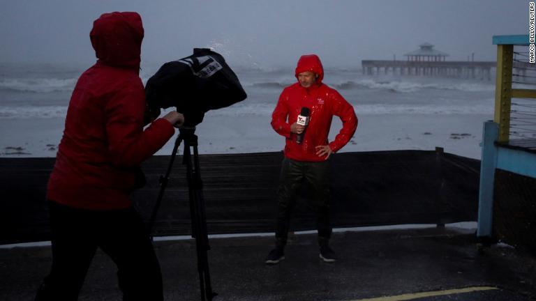 海岸沿いで取材を行うテレビクルー＝米フロリダ州フォートマイヤーズ/Marco Bello/Reuters