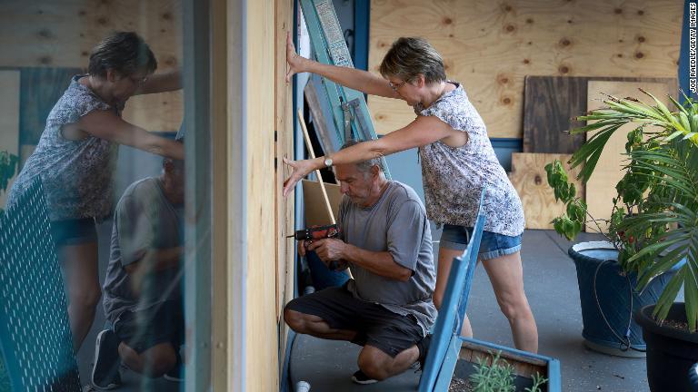 建物を板囲いする人々＝２７日、米フロリダ州セントピートビーチ/Joe Raedle/Getty Images