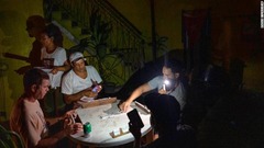 停電中に懐中電灯でドミノをする人々＝２８日、キューバ・ハバナ