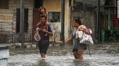 冠水した通りを歩く人々＝２７日、キューバ
