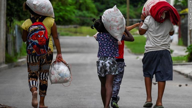 備蓄品を避難所へ運ぶ人々＝２６日、キューバ・ハバナ/Yamil Lage/AFP/Getty Images