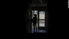 停電が発生し、ドアから被害状況を確認する女性＝２８日、米フロリダ州フォートマイヤーズ