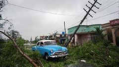 被災地を通り抜ける車＝２７日、キューバのピナール・デル・リオ