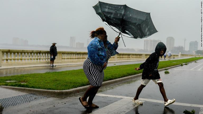 傘がさせないほどの強風に見舞われた＝２８日、米フロリダ州タンパ/Ben Hendren/Anadolu Agency/Getty Images