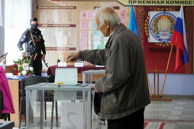ウクライナ東部ルハンスク州の住民投票で投票箱に票を入れる男性＝２７日/AP