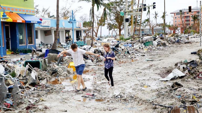 がれきの中を歩く人々＝２９日、米フロリダフロリダ州フォートマイヤーズビーチ/Douglas R. Clifford/Tampa Bay Times/Zuma