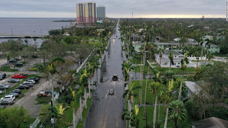 ハリケーン通過後に冠水した道路を進む車＝２９日、フロリダ州フォートマイヤーズ/Joe Raedle/Getty Images