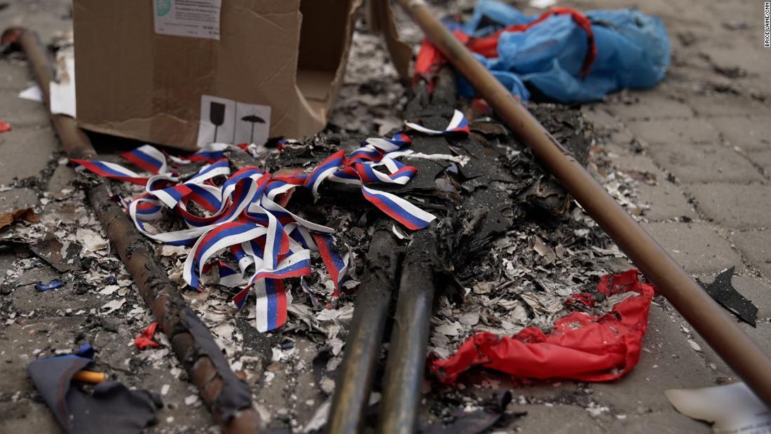 火をつけて燃やされたロシアの国旗や宣伝用の物品/Brice Lâiné/CNN