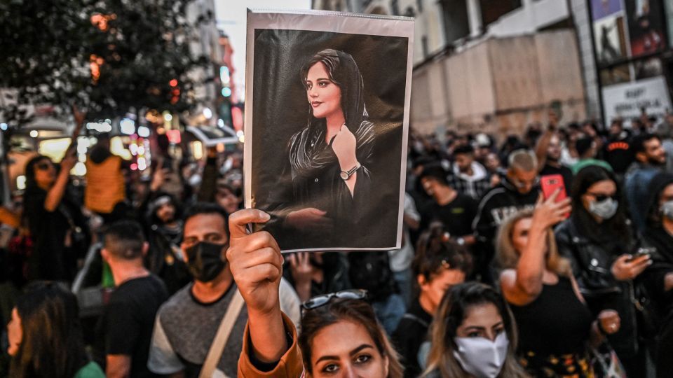 死亡したイラン人女性、マフサ・アミニさんの肖像を掲げるデモ参加者=トルコ・イスタンブール、9月20日撮影