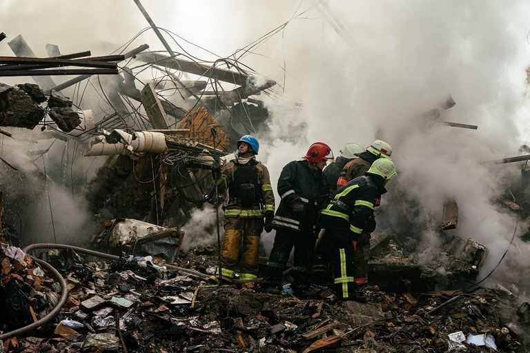 攻撃後にがれきの上に立つウクライナの消防士＝６日、ザポリージャ/Dimitar Dilkoff/AFP/Getty Images