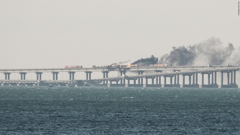 爆発後の「ケルチ橋」。崩落した橋の一部や炎の立ち上る鉄道車両が見える/Stringer/Reuters