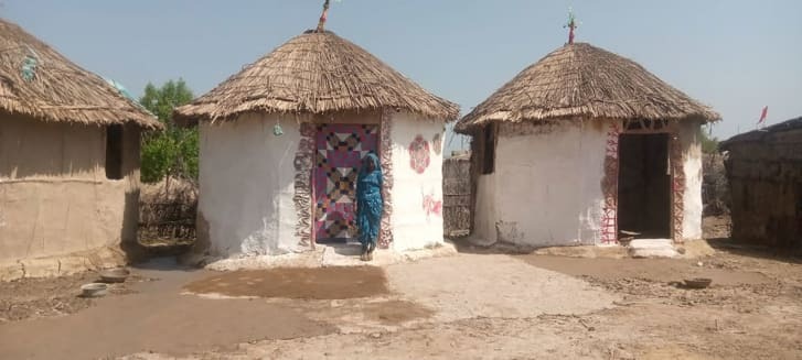カラフルな布地と塗料でシェルターの壁を飾る村の住民/Heritage Foundation of Pakistan