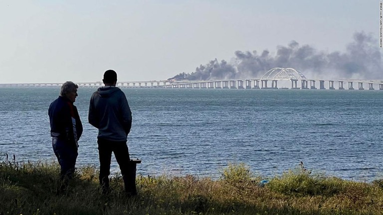ウクライナ南部クリミア半島とロシア本土をつなぐ橋がケルチ付近で爆発した様子を見つめる人々＝８日/Roman Dmitiyev/AFP/Getty Images