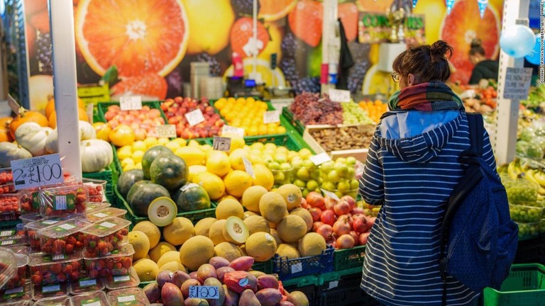 英イングランド中部シェフィールドの市場で野菜や果物を見る買い物客/Dominic Lipinski/Bloomberg/Getty Images