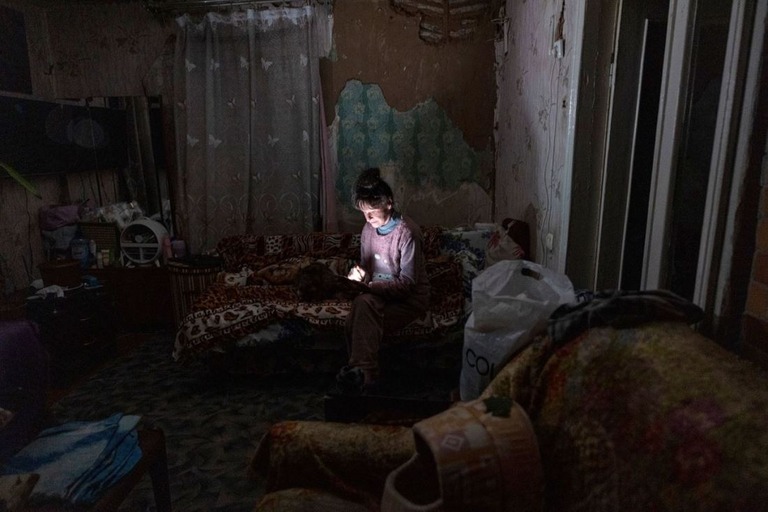 停電の中、スマートフォンを見る女性＝２０日、ウクライナ・ボロジャンカ/Paula Bronstein/Getty Images