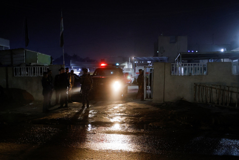 遺体が安置されている病院の外で見張りに立つイラク治安部隊＝７日、イラク・バグダッド/Ahmed Saad/Reuters