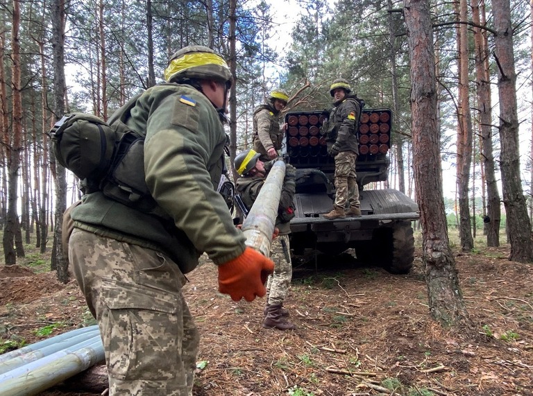 ハルキウ、ルハンスク州境で多連装ロケットシステムにロケットを装填するウクライナ兵/Vitalii Hnidyi/Reuters