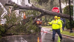木が倒れ、電力の復旧作業に当たる作業員＝１０日、米フロリダ州オカラ