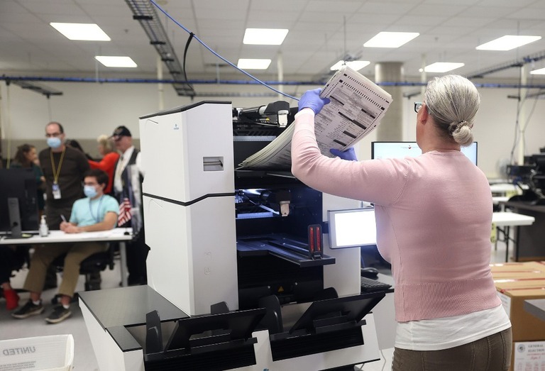 投票用紙をスキャン装置に入れる選管職員＝１０日、アリゾナ州フェニックス/Justin Sullivan/Getty Images