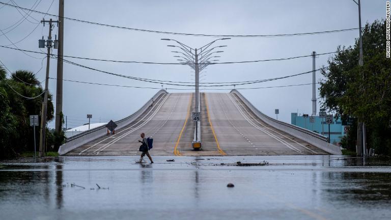ハリケーン「ニコール」の上陸後、冠水した通りを歩く男性＝１０日、米フロリダ州/Ricardo Arduengo/Reuters