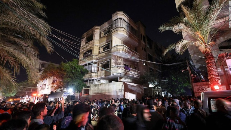 大規模火災が起きた集合住宅の前に集まるパレスチナの人々/Mahmud Hams/AFP/Getty Images