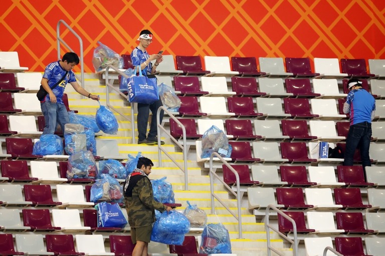 試合後に観客席の清掃を行う日本人サポーター＝２３日、カタール首都ドーハのハリファ国際競技場/Alex Grimm/Getty Images