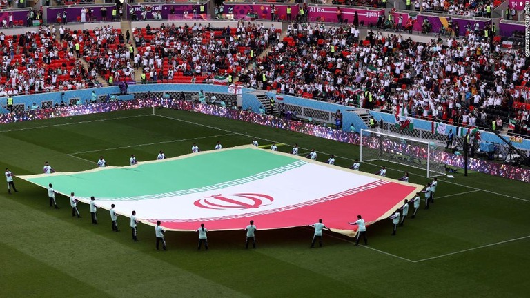 試合前にピッチに掲げられたイラン国旗＝２５日、カタール・ドーハ/Catherine Ivill/Getty Images