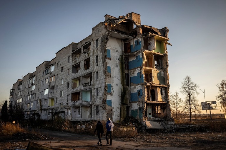 ウクライナ・ボロジャンカの破壊された建物の前を歩く人＝１１月９日/Ed Ram/Getty Images