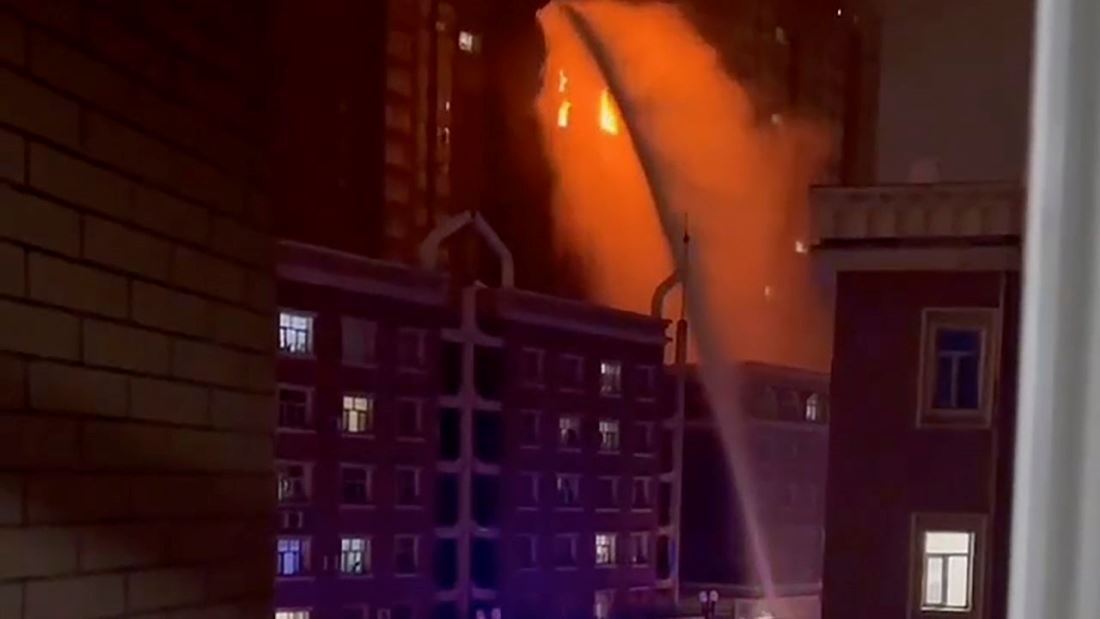 火災の発生したウルムチの集合住宅に消防士が放水する様子/AP