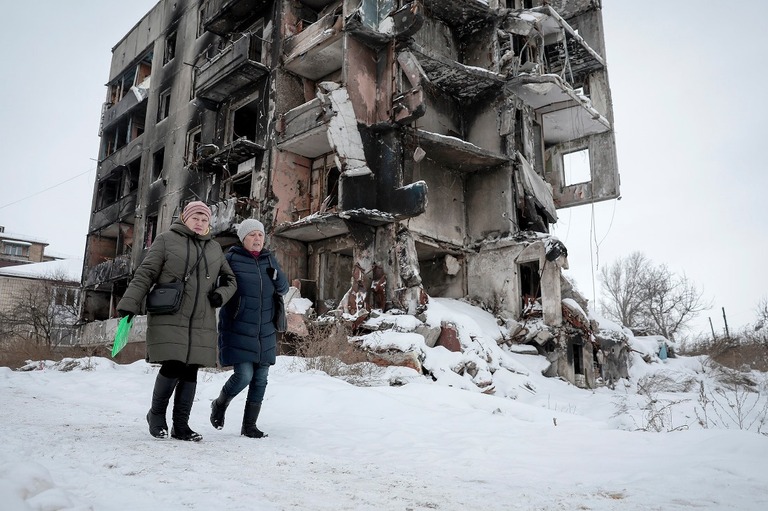 破壊された建物の前の雪道を歩く市民＝キーウ州ボロディアンカ、１２月７日撮影/Jeff J Mitchell/Getty Images