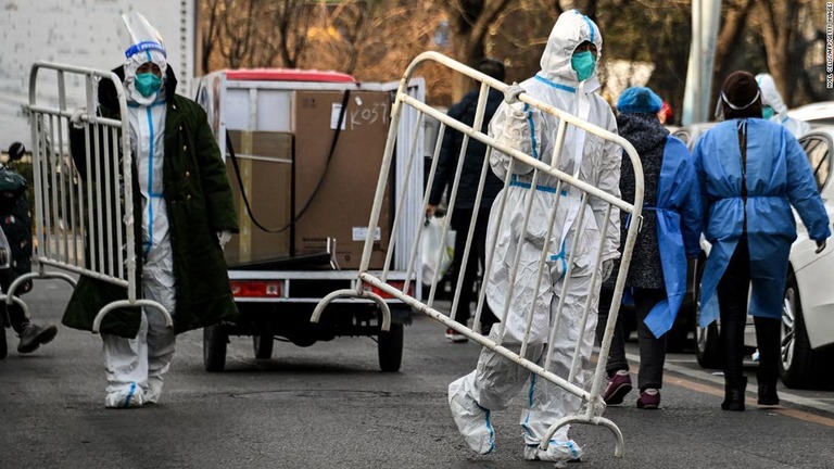 封鎖が解かれた北京の住宅エリアでバリケードを運ぶ医療従事者ら/Noel Celis/AFP/Getty Images