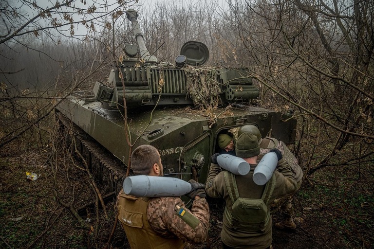 バフムート近くの前線で自走榴弾砲に弾丸を装填するウクライナ軍の砲兵ら/Ihor Tkachov/AFP/Getty Images