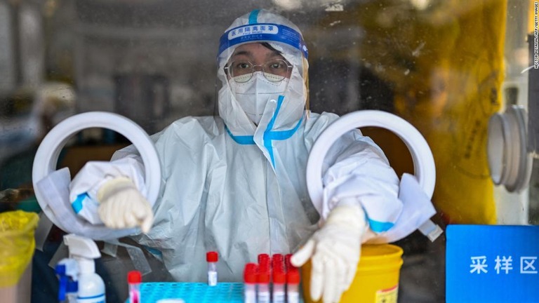 人々がコロナ検査を受けるのを待つ医療従事者＝１９日、上海/Hector Retamal/AFP/Getty Images